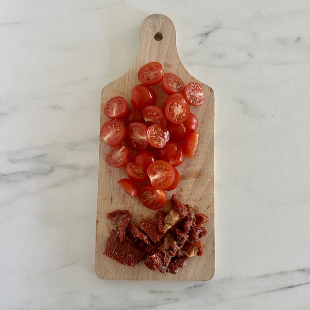 Lavez les tomates cerises et tomates séchées et coupez-les.