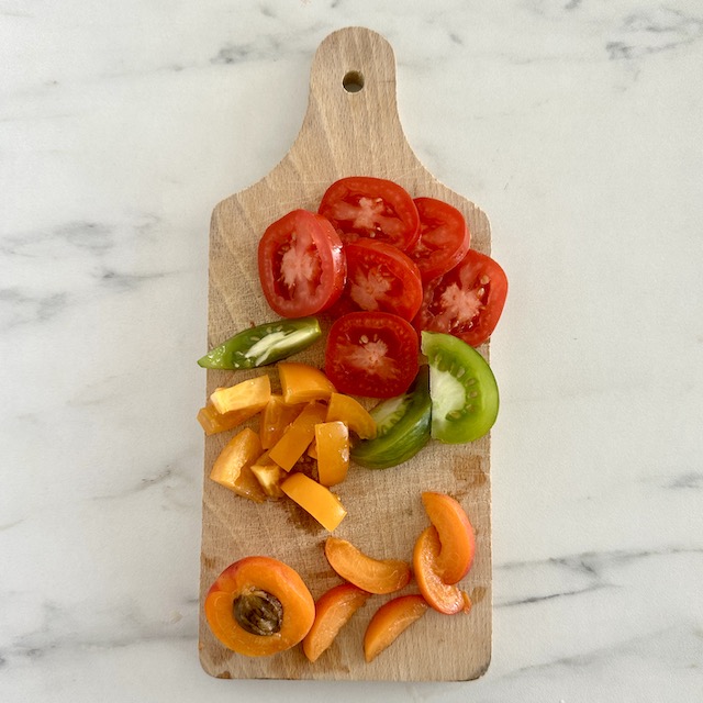 Découpez les tomates anciennes et les abricots en quartiers